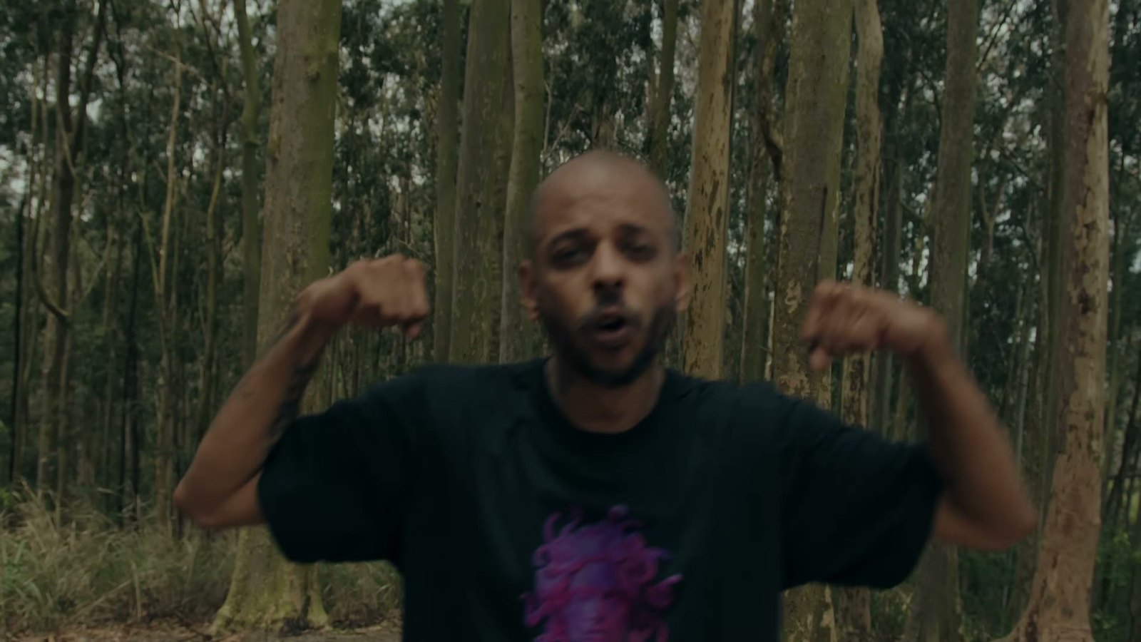 Gutierrez em meio à mata durante cena do clipe da faixa Armas & Rosas, do álbum de 2023